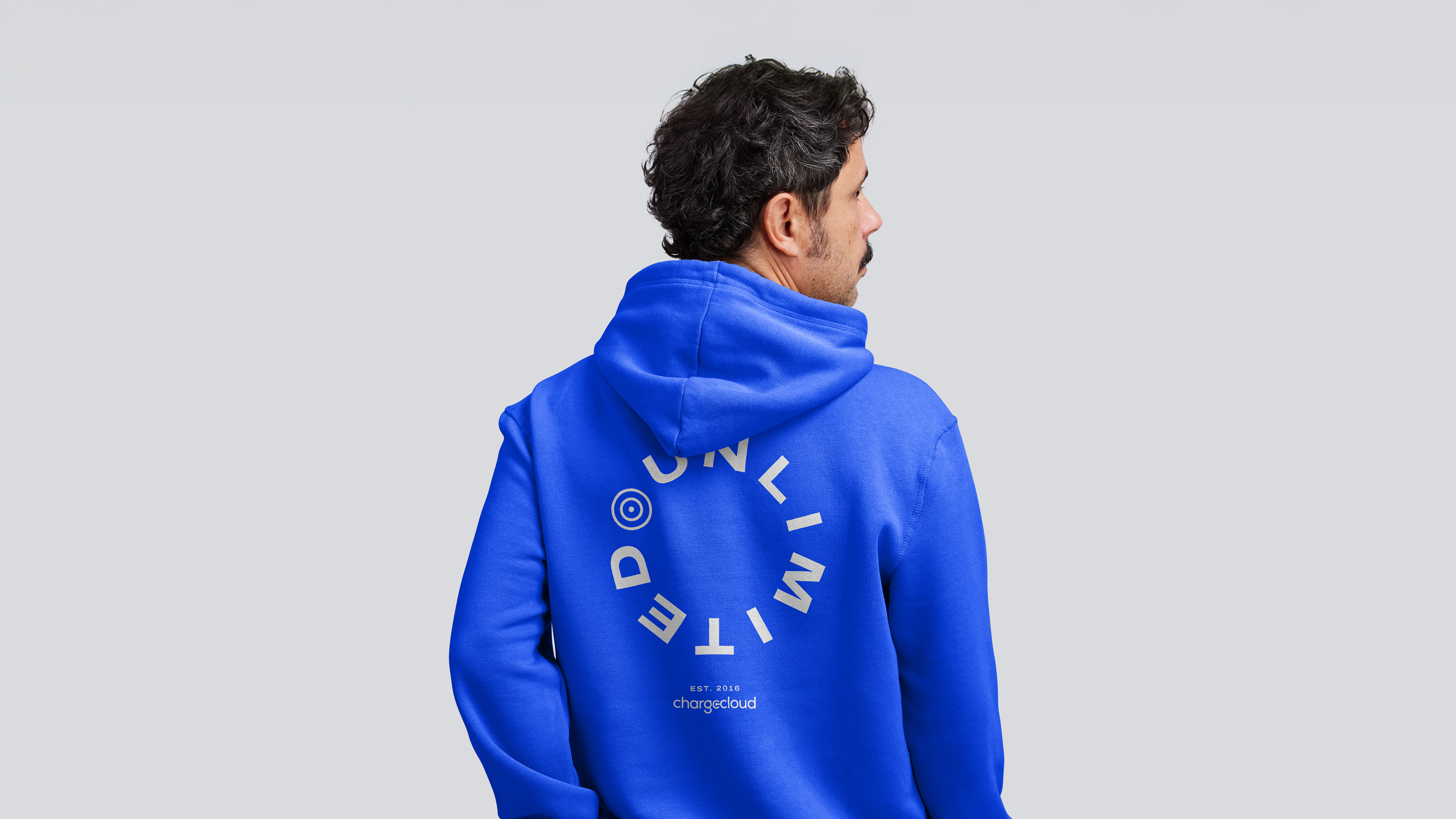 Ein Mann präsentiert die Rückseite eines Hoodies mit einzigartigem chargecloud-Design – moderner Markenauftritt.