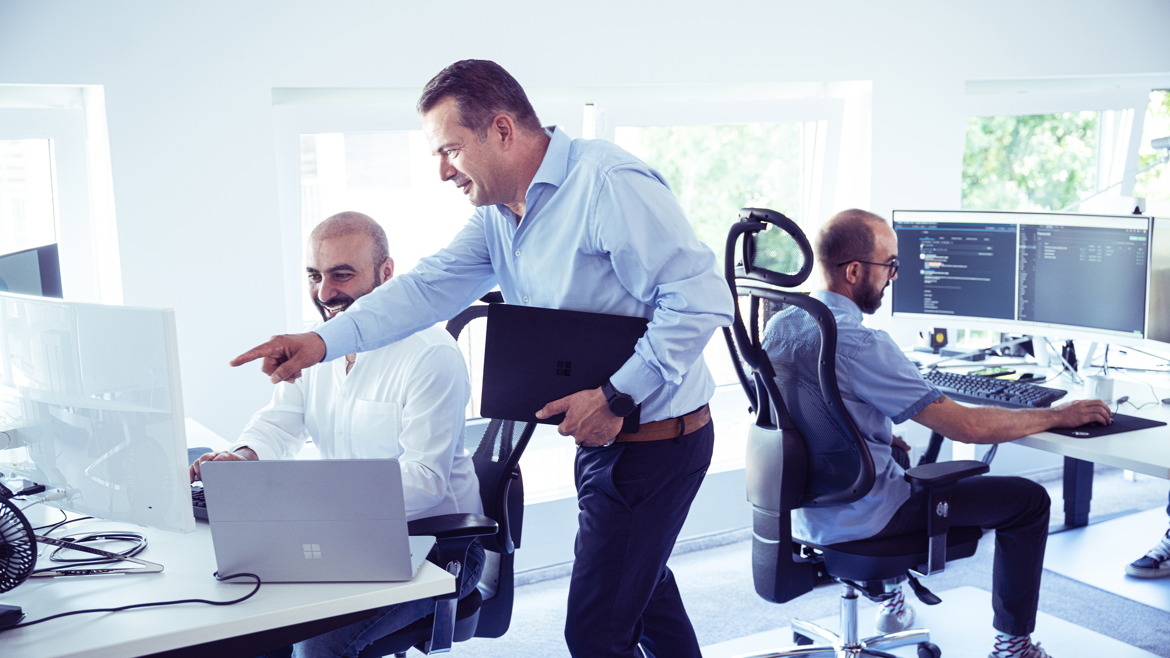 Herr Heymanns im IT-Büro im Gespräch mit zwei Kollegen am Rechner