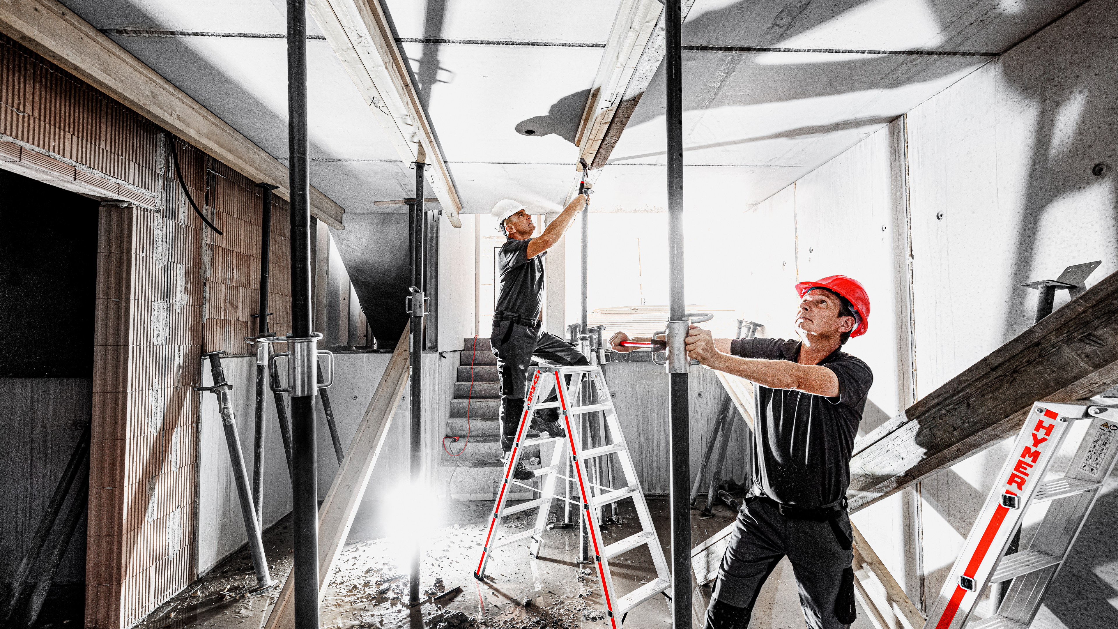 Hymer im Einsatz: Baustellen-Atmosphäre mit Leitern und Arbeitsplattformen – authentisch, sicher, professionell.